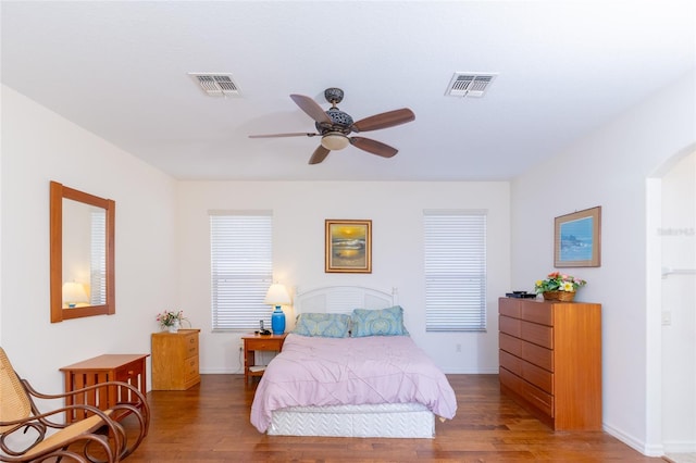 bedroom with dark hardwood / wood-style flooring and ceiling fan