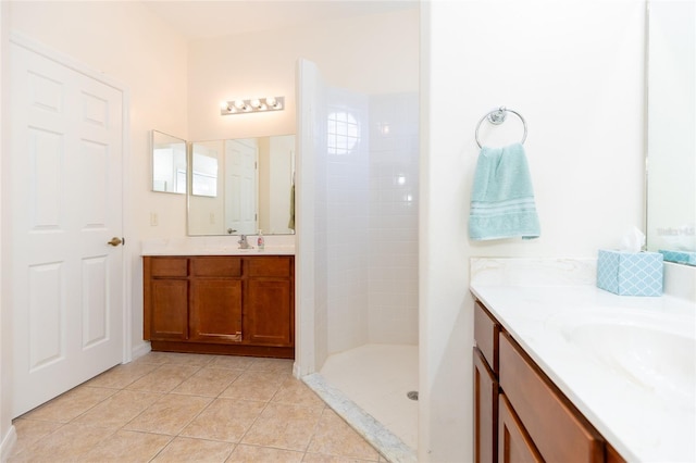 bathroom with vanity, tile patterned flooring, and a tile shower