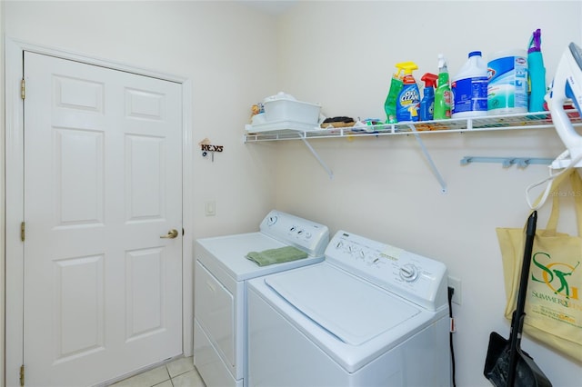 clothes washing area featuring washer and dryer and light tile patterned floors