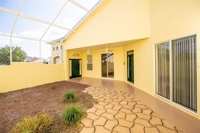 back of property with ceiling fan, glass enclosure, and a patio area