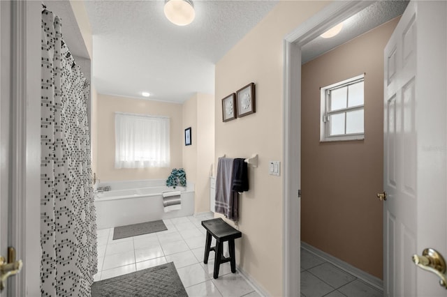 bathroom with tile patterned flooring, plenty of natural light, and a textured ceiling