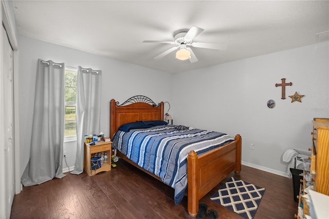 bedroom with dark wood-type flooring, ceiling fan, and a closet