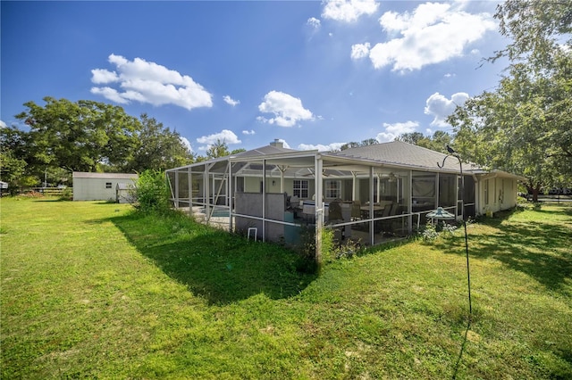 rear view of property featuring a lanai and a lawn