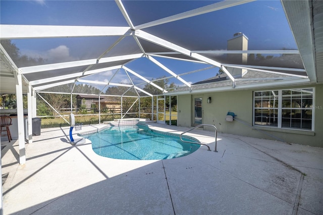 view of pool with glass enclosure and a patio