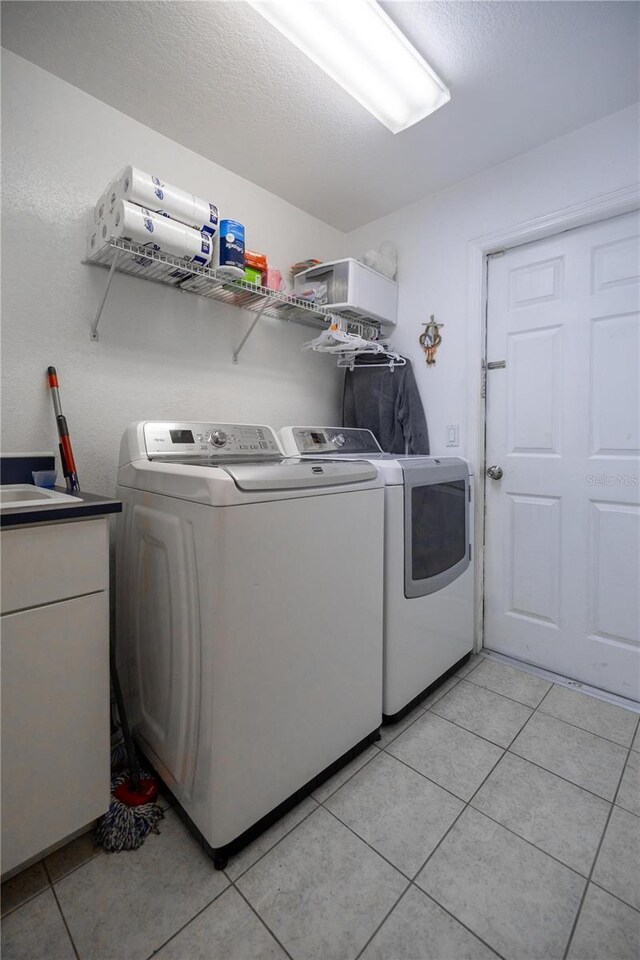 5537 SW 38th St, Ocala, FL 34474 - clothes washing area with washer and clothes dryer, light tile patterned floors, and a textured ceiling