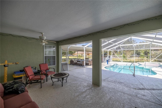 5537 SW 38th St, Ocala, FL 34474 - swimming pool with a ceiling fan, a patio, an outdoor living space with a fire pit, and glass enclosure