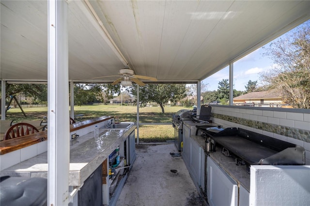 view of patio with grilling area, sink, an outdoor kitchen, and ceiling fan