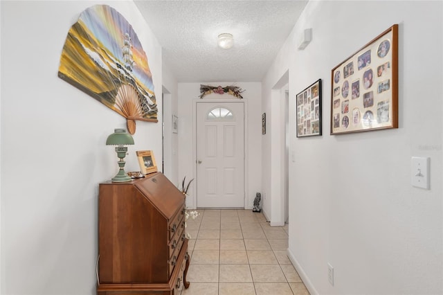 entryway with light tile patterned floors and a textured ceiling