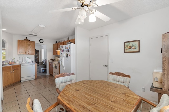 dining room with a textured ceiling, ceiling fan, and light tile patterned flooring