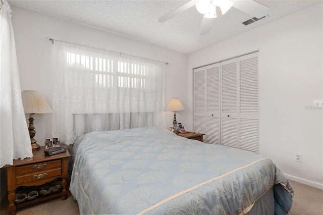 bedroom featuring carpet, ceiling fan, a textured ceiling, and a closet