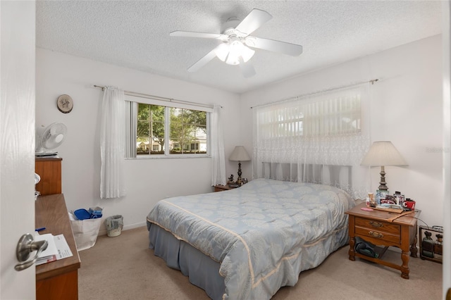 carpeted bedroom featuring ceiling fan and a textured ceiling