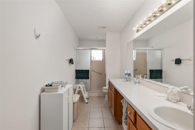 bathroom with walk in shower, vanity, a textured ceiling, tile patterned flooring, and toilet