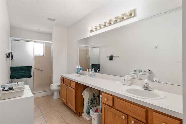 bathroom with tile patterned flooring, a textured ceiling, toilet, and walk in shower