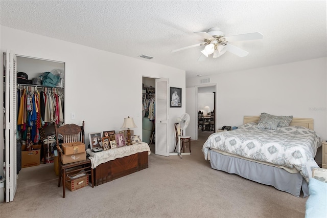 carpeted bedroom featuring ceiling fan and a textured ceiling