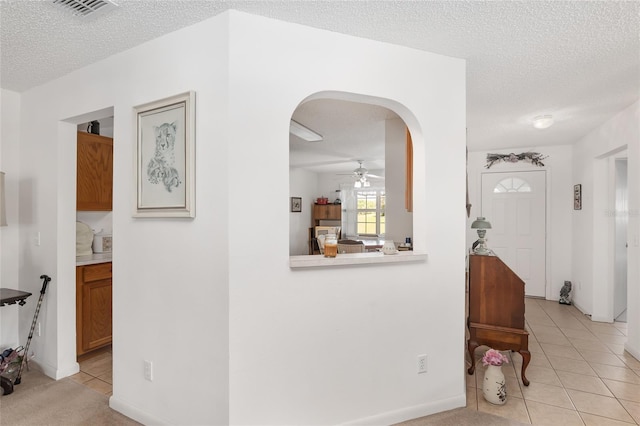 hallway with light tile patterned floors and a textured ceiling