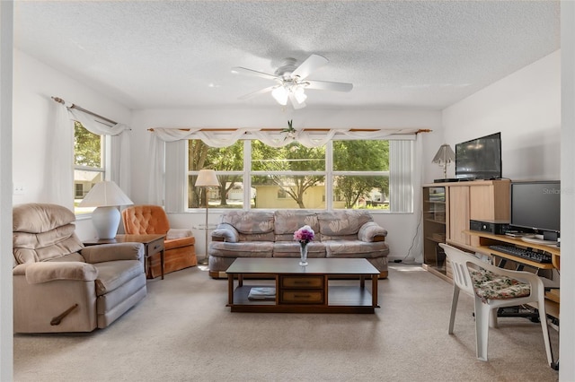 living room with carpet flooring, ceiling fan, and a textured ceiling