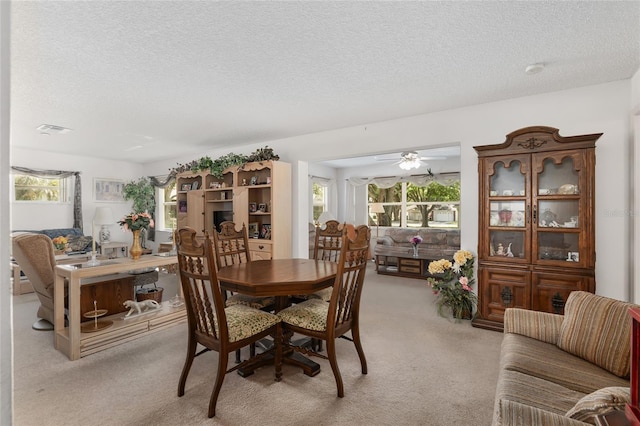 carpeted dining space featuring ceiling fan and a textured ceiling