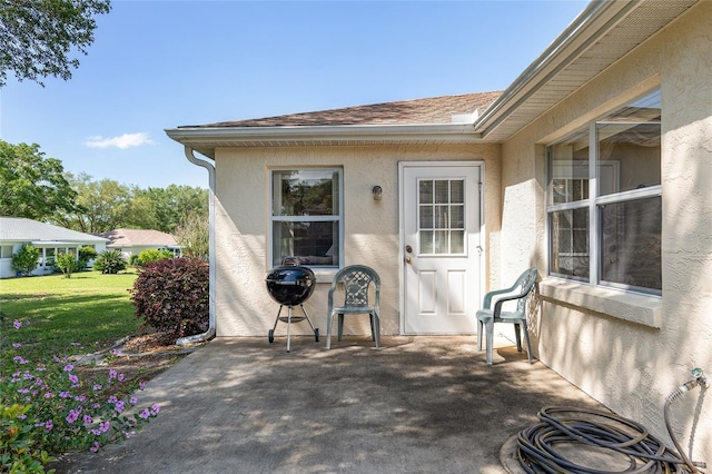 doorway to property with a yard and a patio