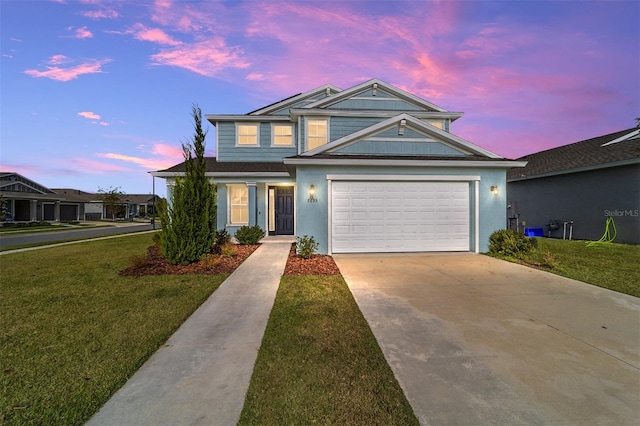 view of front of home with a garage and a lawn