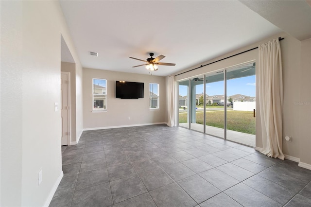 tiled spare room featuring plenty of natural light and ceiling fan