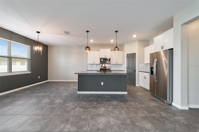 kitchen with white cabinets, hanging light fixtures, sink, a kitchen island with sink, and appliances with stainless steel finishes