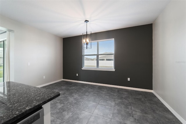 unfurnished dining area featuring dark tile patterned flooring and a chandelier