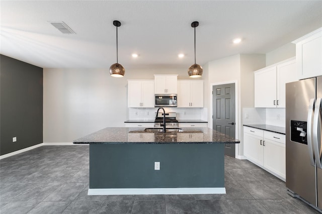 kitchen featuring stainless steel appliances, a center island with sink, sink, hanging light fixtures, and white cabinets