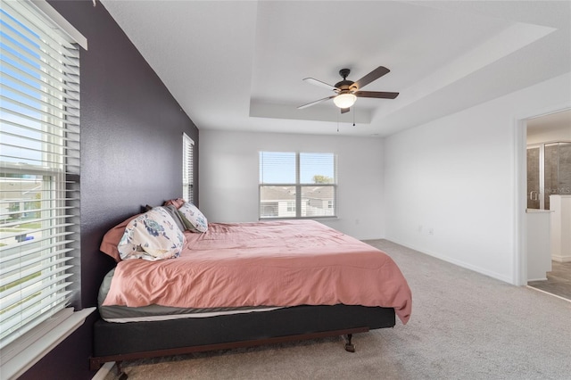 bedroom featuring ceiling fan, carpet flooring, and a tray ceiling