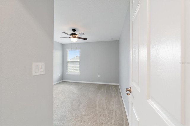 carpeted spare room with ceiling fan