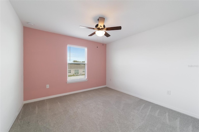 spare room featuring light colored carpet and ceiling fan