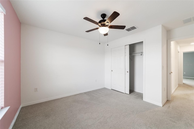 unfurnished bedroom featuring a closet, light colored carpet, and ceiling fan