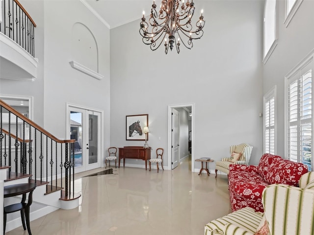 living room featuring a high ceiling, french doors, an inviting chandelier, ornamental molding, and light tile patterned floors