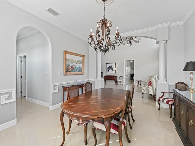 tiled dining room with crown molding, a chandelier, and ornate columns