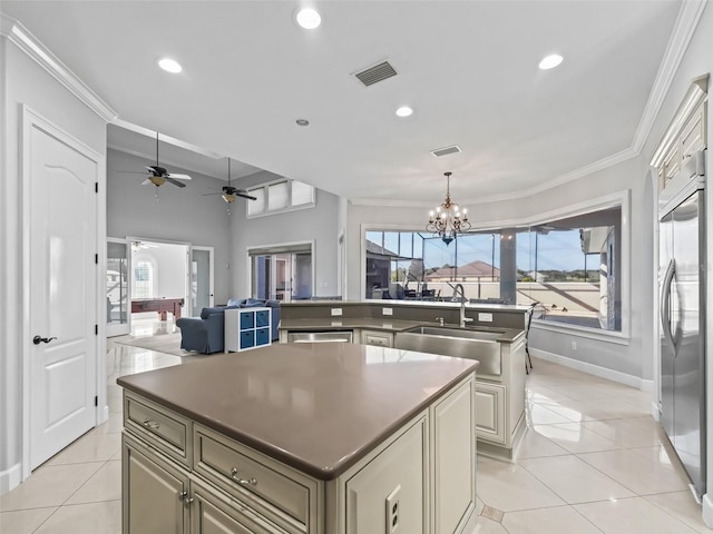 kitchen with sink, a center island, stainless steel built in fridge, and light tile patterned flooring