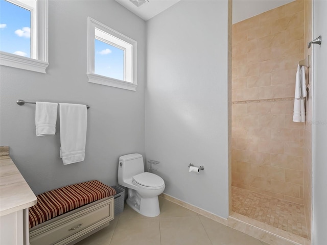 bathroom featuring plenty of natural light, tiled shower, vanity, and tile patterned flooring