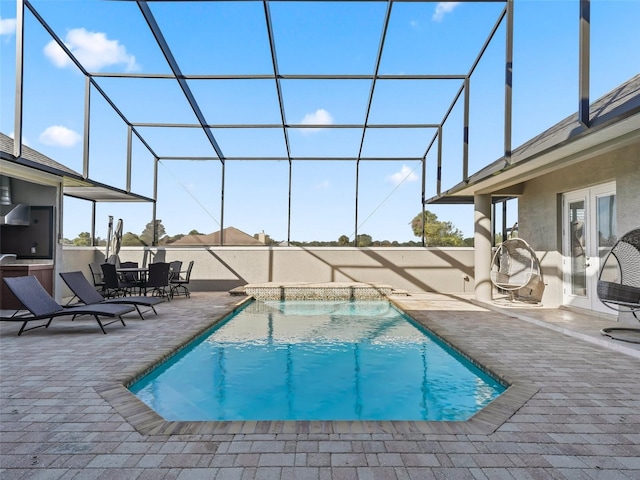 view of pool with glass enclosure and a patio area