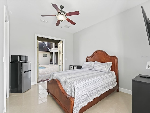 bedroom with ceiling fan, light tile patterned floors, and stainless steel fridge