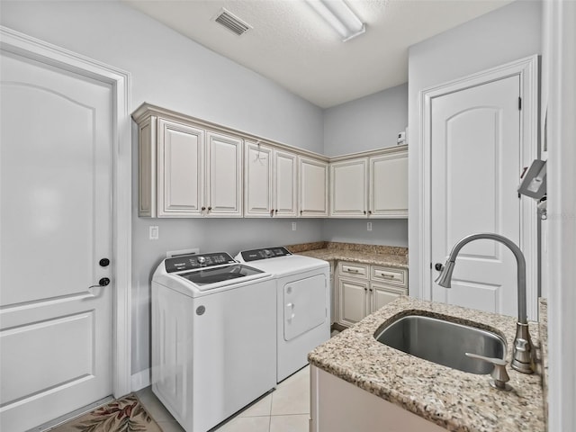 washroom featuring cabinets, washer and clothes dryer, sink, and light tile patterned flooring