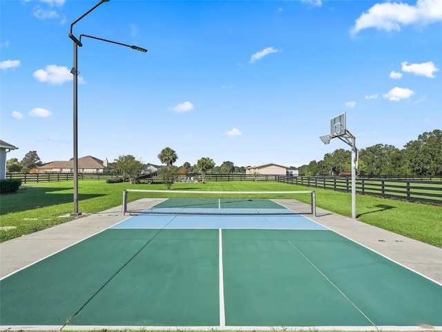 view of sport court with a lawn