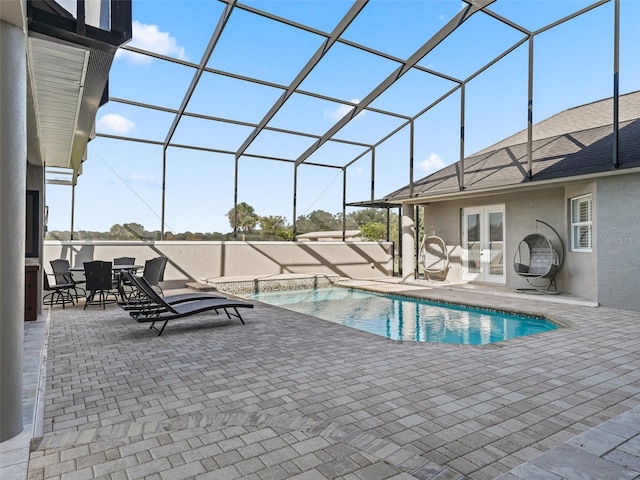 view of pool with glass enclosure, a patio area, and french doors