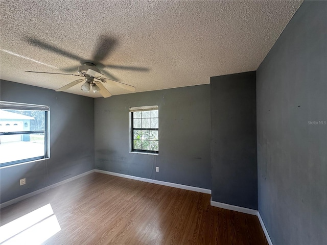 spare room featuring a textured ceiling, ceiling fan, hardwood / wood-style floors, and plenty of natural light