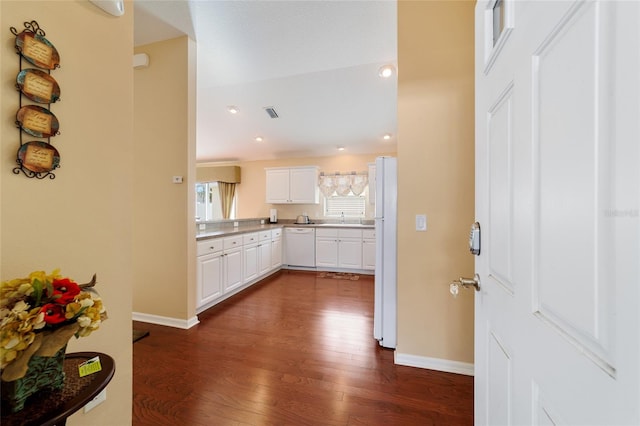 kitchen with white cabinetry, sink, white appliances, and dark wood-type flooring