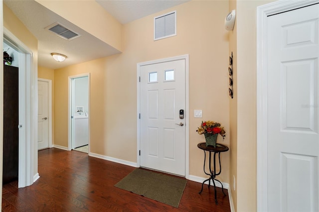 foyer entrance with dark hardwood / wood-style floors and a textured ceiling