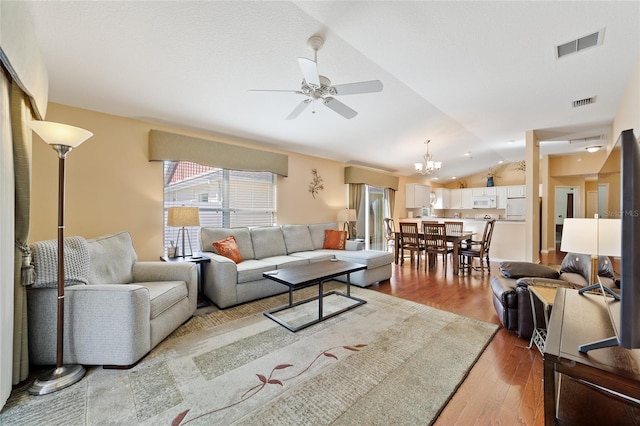 living room featuring ceiling fan with notable chandelier, lofted ceiling, and light hardwood / wood-style flooring