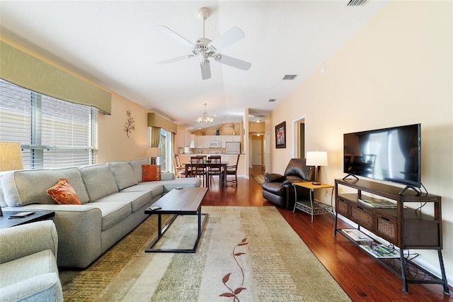 living room with dark hardwood / wood-style floors, lofted ceiling, and ceiling fan with notable chandelier