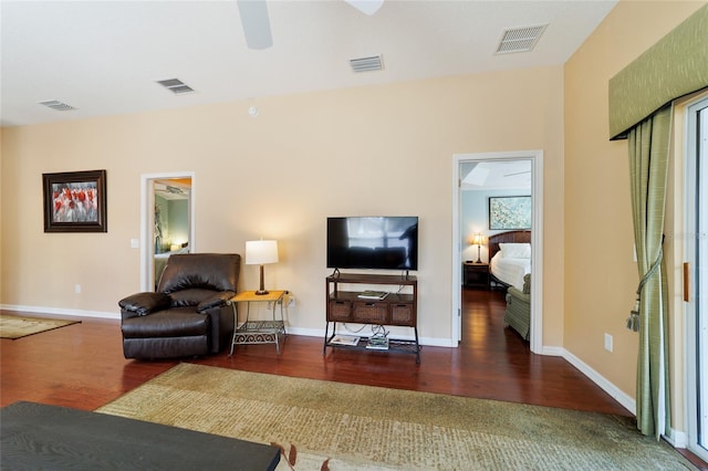 living room featuring ceiling fan and dark wood-type flooring