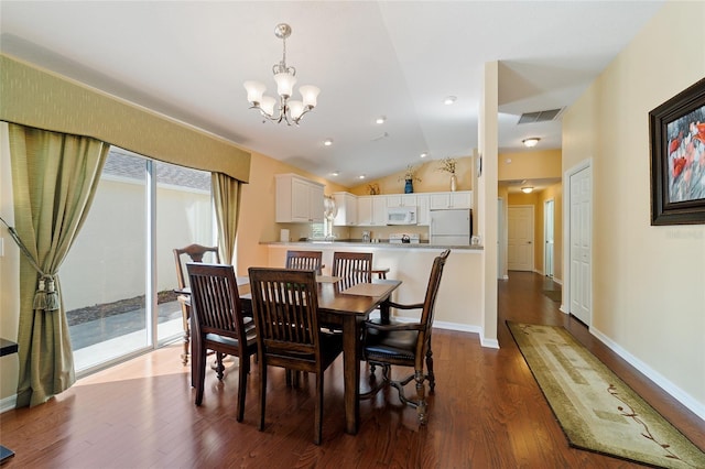 dining room with a notable chandelier, vaulted ceiling, and hardwood / wood-style flooring