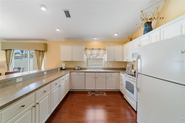 kitchen with kitchen peninsula, white cabinetry, dark hardwood / wood-style floors, and white appliances