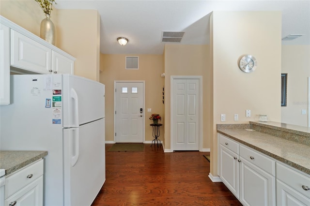 kitchen featuring white fridge, white cabinetry, and dark hardwood / wood-style floors