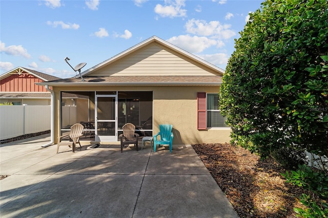 rear view of property featuring a patio area and a sunroom